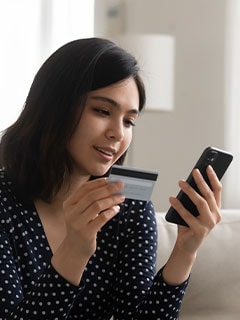 woman using cellphone to avail credit card benefits