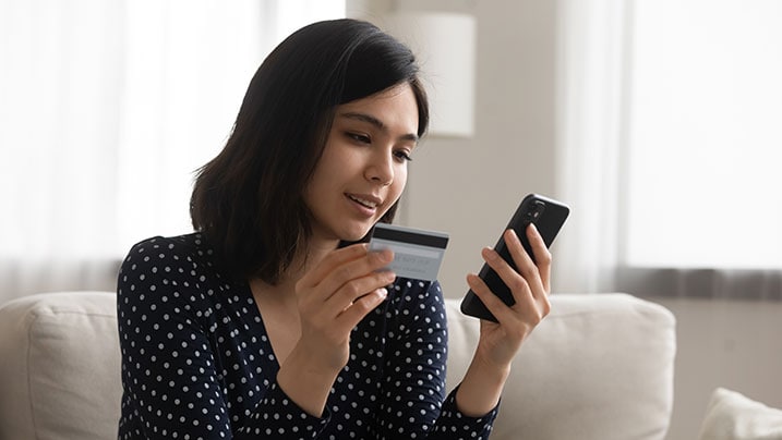woman using cellphone to avail credit card benefits