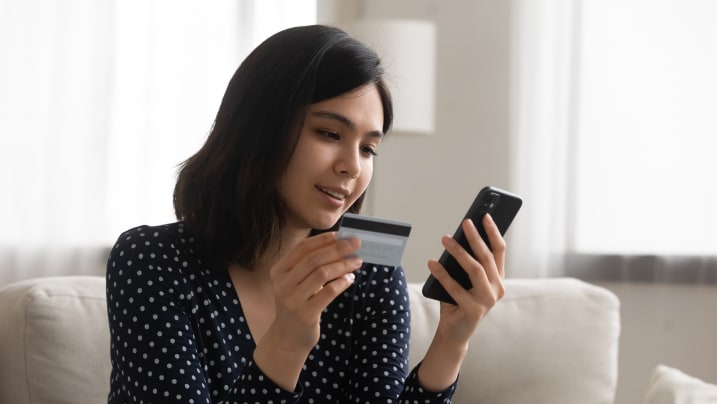 woman holding a credit card, entering info