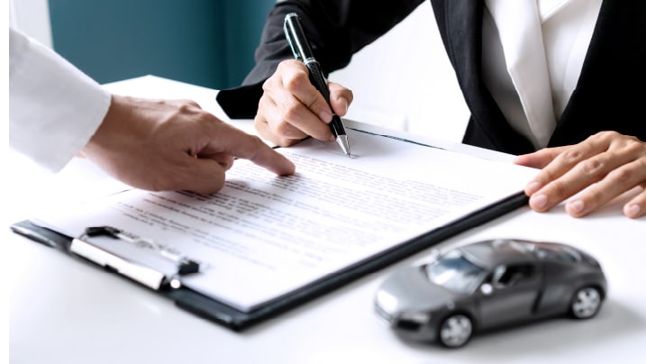 a person signing car insurance document 