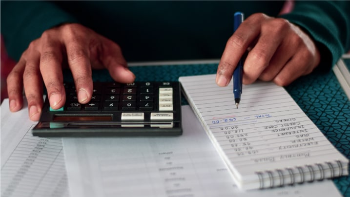  man calculating household expenses with a calculator